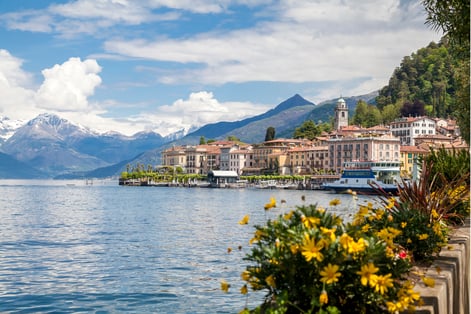 Vista panorámica del Lago de Como con el pueblo y montañas alpinas de fondo en un día soleado
