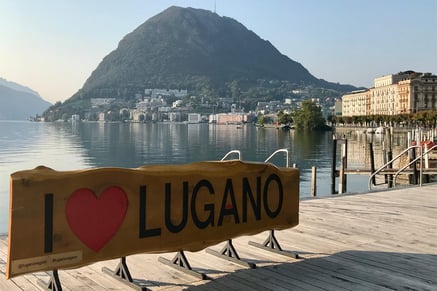 Vista del Lago de Lugano con el cartel I Love Lugano y montañas de fondo