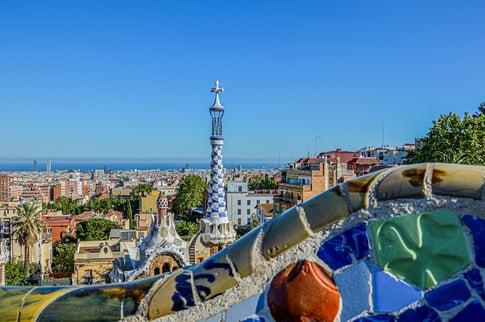 Vista panorámica del Park Güell en Barcelona con el famoso banco ondulado de mosaicos y la ciudad al fondo, una de las obras más emblemáticas de Gaudí.