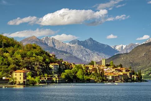 Vista panorámica del Lago de Como con el pueblo y montañas alpinas de fondo en un día soleado