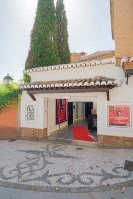 Fachada del Teatro Flamenco Granada, espacio escénico dedicado al arte flamenco en pleno centro de Granada, con entrada decorada y alfombra roja.