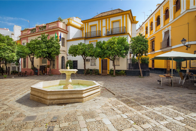 Panorámica de una plaza ubicada en el Barrio de Santa Cruz de Sevilla, con una fuente octogonal en el centro