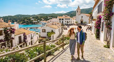 Una pareja pasea por la calle empedrada de un pueblo costero bajo el sol