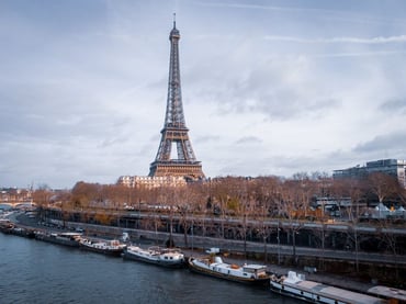 Vista panorámica de la Torre Eiffel en París desde el río Sena con barcos amarrados en la orilla