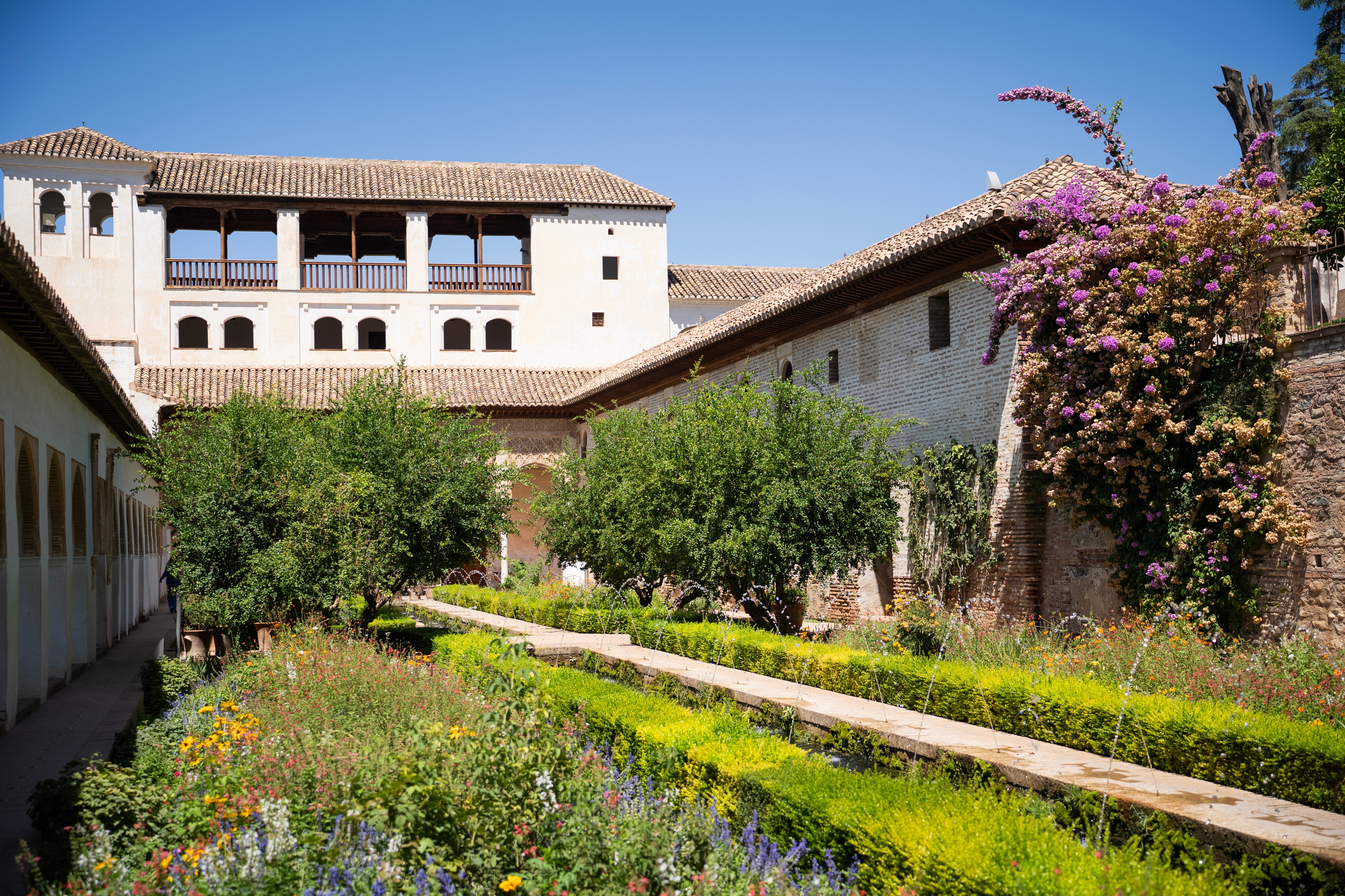 Imagen de uno de los patios ajardinados con una fuente que recorre el centro del mismo, en el Generalife