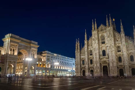 Vista nocturna de la Piazza del Duomo de Milán, con la catedral iluminada y la Galería Vittorio Emanuele II al fondo.